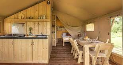 Indendørs billede af lodge Sunshine på Petite Suisse med træmøbler, køkken og spisebord i Belgien.