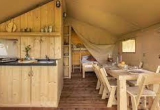 Foto interior del lodge Sunshine en Petite Suisse, Bélgica, con muebles de madera, cocina y comedor.