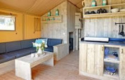 Cozy lodge interior with wooden furnishings and seating area at Sunshine in Petite Suisse, Belgium.
