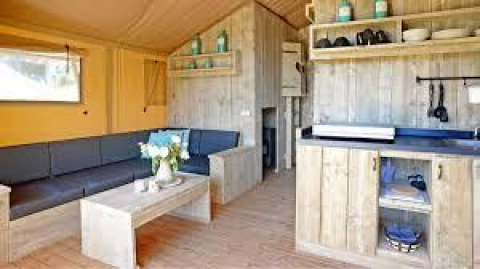 Interno di lodge accogliente con arredi in legno presso Sunshine a Petite Suisse, Belgio.