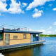 Moderne woonboot Floating House bij Vakantiepark Leukermeer in Nederland met dakterras en uitzicht op het water.
