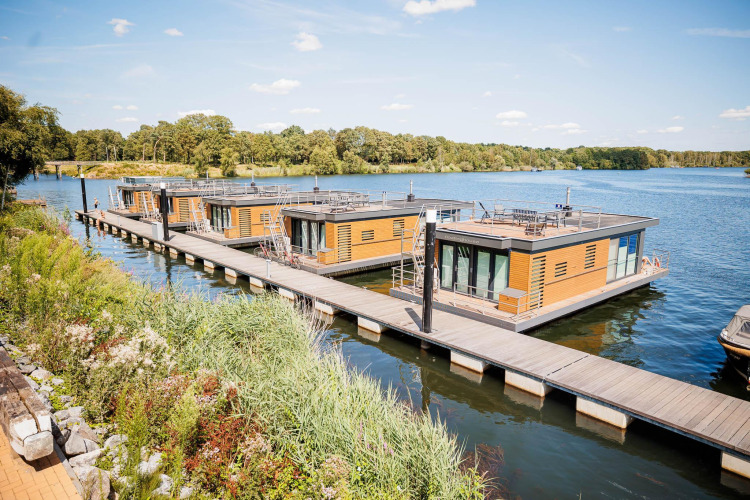 Moderne drijvende huisboten bij Vakantiepark Leukermeer in Nederland, omringd door natuur en water.