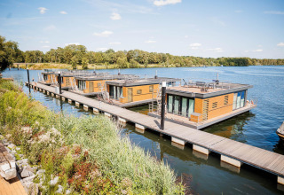 Moderne Hausboote am Wasser im Vakantiepark Leukermeer, Niederlande, mit grünem Uferblick.