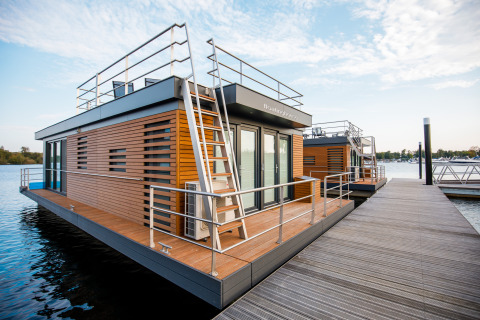 Houseboat Floating House bij Vakantiepark Leukermeer in Nederland, aangemeerd aan een moderne steiger.