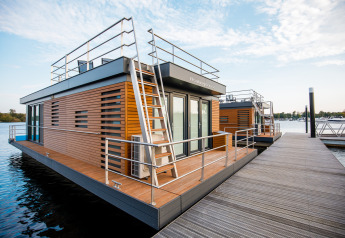 Moderne husbåd Floating House ved Vakantiepark Leukermeer i Holland, fortøjet ved en træbro.