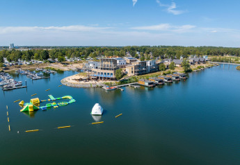 Vista dall'alto di Floating House al Vakantiepark Leukermeer nei Paesi Bassi con porto turistico e giochi d'acqua.