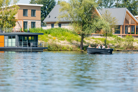 Houseboat Floating House e case moderne viste dal lago a Vakantiepark Leukermeer, Paesi Bassi.
