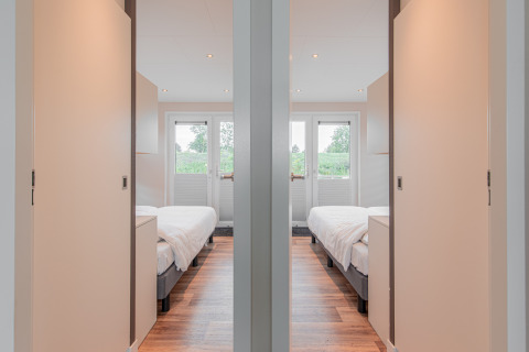 Binnenaanzicht van twee identieke slaapkamers op een woonboot bij Floating House, Vakantiepark Leukermeer, Nederland.