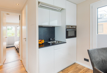 Moderne kitchenette in een woonboot te Vakantiepark Leukermeer, Nederland, met spoelbak en fruitschaal.