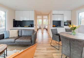 Helles, modernes Wohnzimmer einer Hausbootunterkunft im Vakantiepark Leukermeer mit Küchen- und Sitzbereich.