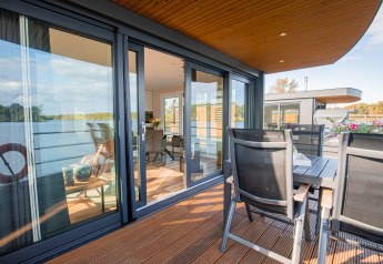 Casa galleggiante moderna con porte a vetro, terrazza e vista lago a Vakantiepark Leukermeer, Paesi Bassi.