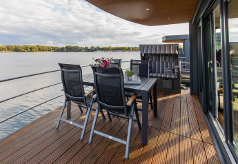 Terrazza di una houseboat al Floating House, Vakantiepark Leukermeer, Paesi Bassi, con vista lago.
