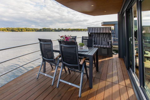 Terrasse på en husbåd ved Floating House, Vakantiepark Leukermeer, med udsigt over søen i Holland.