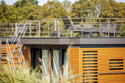 Houseboat 'Floating House' bij Vakantiepark Leukermeer, Nederland, met dakterras en buitenstoelen.