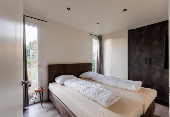 Moderne slaapkamer in Beachlodge Deluxe ǀ to aan Vakantiepark Leukermeer, Nederland, met dubbelbed