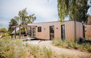 Beachlodge Deluxe moderna en Vakantiepark Leukermeer, Países Bajos, con terraza de madera y jardín.