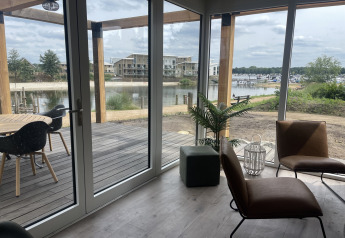 Blick aus dem Beachlodge Deluxe im Vakantiepark Leukermeer, Niederlande, auf Terrasse und See.