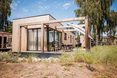 Outdoor view of Beachlodge Deluxe at Vakantiepark Leukermeer, modern wooden lodge in the Netherlands.