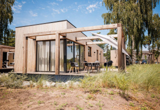 Outdoor view of Beachlodge Deluxe at Vakantiepark Leukermeer, modern wooden lodge in the Netherlands.