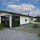 Velthorst-Hütte mit moderner Fassade, großen Fenstern und Terrasse mit Esstisch und Stühlen.