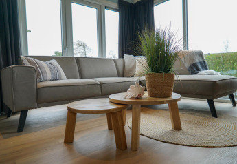 Salon moderne d'un chalet Velthorst à EuroParcs Parc du Soleil aux Pays-Bas avec canapé et table.