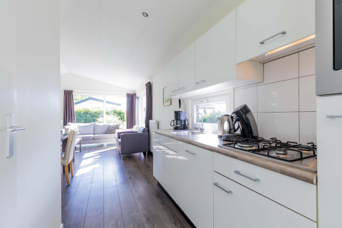 Lichte keuken en woonkamer in een Velthorst cabin bij EuroParcs Parc du Soleil in Nederland, modern ingericht.