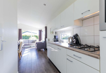 Cocina luminosa y sala de estar en una cabaña Velthorst de EuroParcs Parc du Soleil en los Países Bajos.