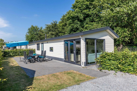 Velthorst-huisje bij EuroParcs Parc du Soleil in Nederland, met terras, tuinmeubelen en veel groen.