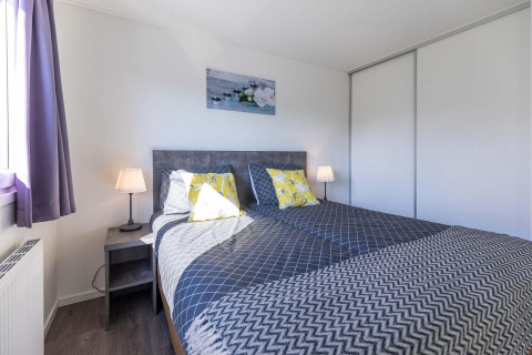 Modernes Schlafzimmer in einer Velthorst-Hütte bei EuroParcs Parc du Soleil, mit Doppelbett und viel Licht.