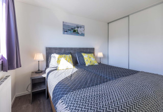 Camera moderna in una cabina Velthorst a EuroParcs Parc du Soleil, con letto matrimoniale e luce naturale.