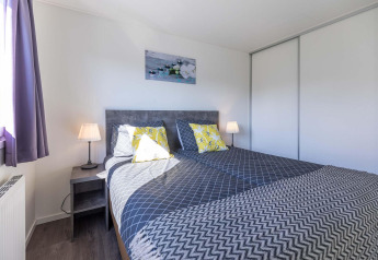 Modernes Schlafzimmer in einer Velthorst-Hütte bei EuroParcs Parc du Soleil, mit Doppelbett und viel Licht.