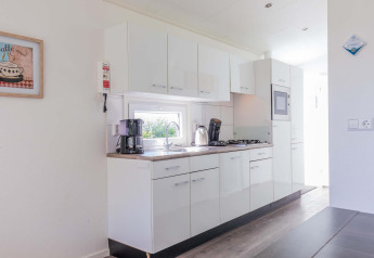 Cocina moderna en una cabaña Velthorst en EuroParcs Parc du Soleil, Países Bajos, con gabinetes blancos.