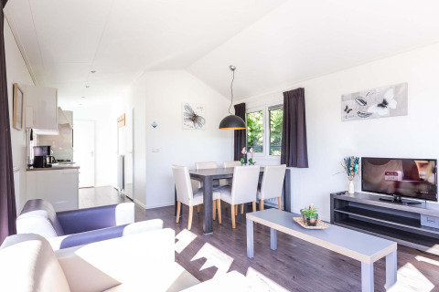 Helles Wohnzimmer in der Velthorst-Hütte im EuroParcs Parc du Soleil, Niederlande, mit moderner Einrichtung.