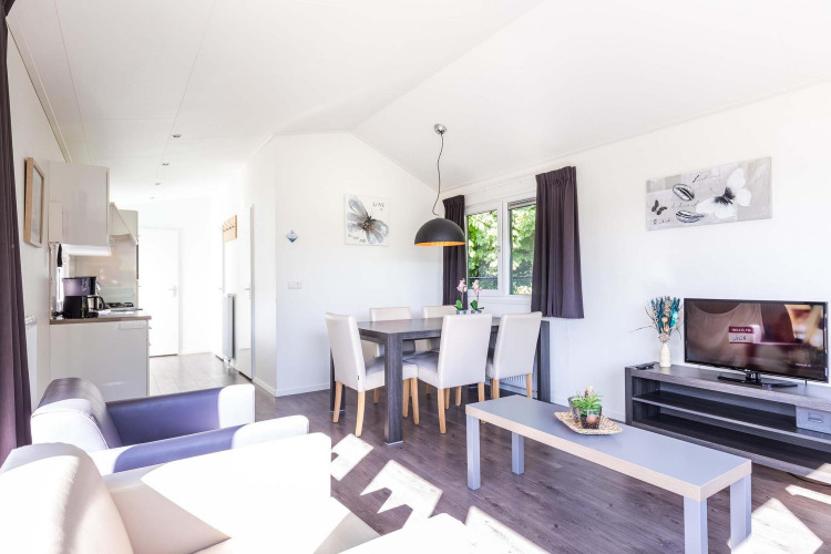 Sala luminosa en la cabaña Velthorst de EuroParcs Parc du Soleil, Países Bajos, con decoración moderna.