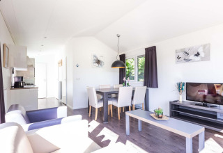 Lichte leefruimte in het Velthorst-huisje bij EuroParcs Parc du Soleil, Nederland, met modern interieur.