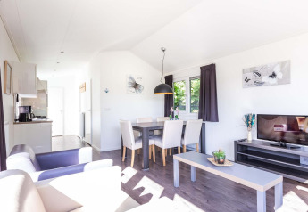 Helles Wohnzimmer in der Velthorst-Hütte im EuroParcs Parc du Soleil, Niederlande, mit moderner Einrichtung.