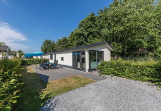 Außenansicht der Velthorst-Hütte im EuroParcs Parc du Soleil, Niederlande, mit Terrasse und Gartenmöbeln.
