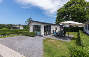 Velthorst-Hütte bei EuroParcs Parc du Soleil in den Niederlanden mit Terrasse, Gartenmöbeln und Sonnenschirm.