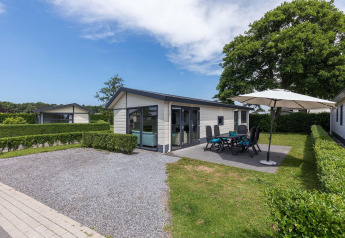 Velthorst-hut bij EuroParcs Parc du Soleil in Nederland met patio, tuinset en grote parasol in de tuin.