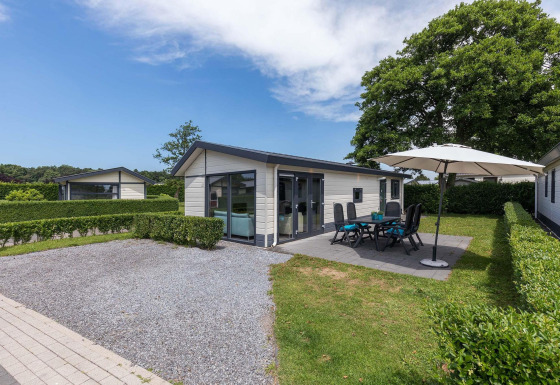 Velthorst-Hütte bei EuroParcs Parc du Soleil in den Niederlanden mit Terrasse, Gartenmöbeln und Sonnenschirm.