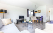 Lichte, moderne woonkamer in een Velthorst-chalet bij EuroParcs Parc du Soleil met eethoek.