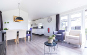 Lyst og moderne opholdsområde og køkken i en Velthorst-hytte på EuroParcs Parc du Soleil i Holland.