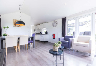 Salon lumineux et moderne avec cuisine dans un chalet Velthorst à EuroParcs Parc du Soleil, Pays-Bas.