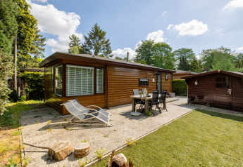Außenansicht des Tiny Chalet im Bungalowpark Het Verscholen Dorp, Niederlande, mit Terrasse und Garten.