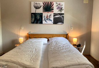 Soveværelse i Tiny Chalet på Bungalowpark Het Verscholen Dorp i Holland, med dobbeltseng og moderne kunst.