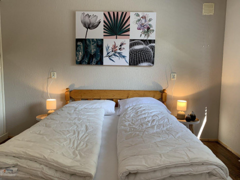 Dormitorio en Tiny Chalet del Bungalowpark Het Verscholen Dorp, Países Bajos, con cama doble y arte mural.