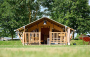 Safari-teltet Villatent Compact på Camping Betuwe i Holland, omgivet af grønne træer og græsplæne.