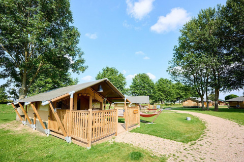 Villatent Compact safaritent bij Camping Betuwe in Nederland, omringd door grasvelden en bomen.