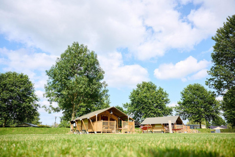 Safaritent Villatent Compact op Camping Betuwe in Nederland, omringd door bomen en een groene grasmat.