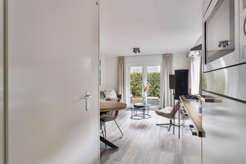 Modern two-person lodge at De Thijmse Berg, Netherlands, with cozy interior, kitchen, and garden access.